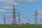 Electricity pylon silhouetted against blue sky sunshine background