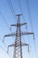 Electricity pylon silhouetted against blue sky sunshine background. High voltage tower.