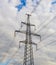 Electricity pylon silhouetted against blue sky sunshine background. High voltage tower.