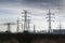 Electricity pylons with distribution power station blue cloudy sky background