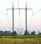 Electricity Pylons Trailing Away in Field. Power-transmission po