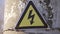 Electricity safety sign on the pole next to the transformer. Yellow sign lightning danger high voltage concept