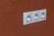 Electricity socket. White colour. orange background. shallow depth of field. on the nest there is rubbed off from using