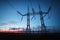 Electricity transmission pylon silhouetted against blue sky at d