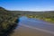 An electricity transmission tower and cables across a river in regional Australia