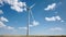 Electricity wind generator on bright cloudy sky background - wind energy and technology concept