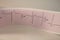 Electrocardiogram strip with heartbeat represented on paper. Graph paper for cardiology studies