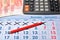 Electronic calculator, red pen, banknotes five thousand rubles a