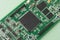 Electronic chip component. Printed circuit boards PCB on green background. Minimal industry backdrop