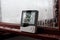 Electronic clock, calendar, thermometer, and hygrometer, against the background of condensation on glass, high humidity. Digital