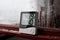 Electronic clock, calendar, thermometer, and hygrometer, against the background of condensation on glass, high humidity. Digital