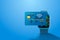 Electronic credit card and watch icon, finance technology, blue background.