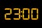 Electronic digital clock with orange numbers on a black background shows the time. Twenty three zero o`clock at night. Isolate,