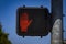 Electronic Do Not Walk sign red with hand at cross walk against blue sky