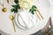 Elegance classic table setting with white dishes, gold cutlery and hydrangea flower