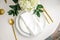 Elegance classic table setting with white dishes, gold cutlery and hydrangea flower, top view