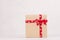 Elegance festive a gift box of kraft paper with a red ribbon and bow on white wood board with copy space.