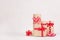Elegance festive various gift boxes with red ribbons and bows on white wood board with copy space.