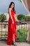 Elegance in Red: Fashionable Woman on Garden Balcony