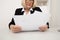 Elegant adult office worker in eyeglasses working with paper indoor.