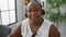 Elegant african american woman boss, working with customer service headset in her indoor office