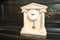 Elegant antique clock. Clock with Greek temple. Marble clock on black piano