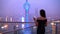 Elegant asian woman in gown drinking white wine glass at rooftop bar terrace