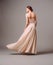 Elegant backless moscato dress. Beautiful pink chiffon evening gown. Studio portrait of young ginger woman. Transformer dress idea
