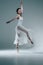elegant ballerina in white dress dancing