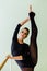 Elegant beautiful ballerina with a perfect body doing stretching exercise.