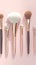 Elegant beauty brushes, white and gold, on gentle pink background