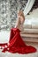 Elegant blond woman model wearing in luxurious red gown with lon