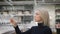 Elegant blonde in a kitchen utensils store. A woman chooses new wine glasses for a party.