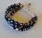 An elegant bracelet with black freshwater pearls on white surface