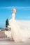 Elegant bride woman in fashion wedding dress over blue sky. Attractive young blond female in long gown. outdoor photo.