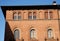 Elegant building with a side of the sunlit sky and morning sun in downtown Lodi in Lombardy (Italy