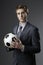 Elegant businessman holding a soccer ball