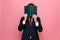 Elegant businessman in suit hiding behind book