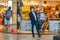 An elegant businessman wearing coronavirus protective mask walks in front of a made in italy leather shop at Pisa Airport, Italy