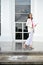 Elegant businesswoman in white formal suit standing outside of the building