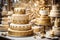 An elegant cake shop display showcasing a tiered, gold-frosted Christmas cake adorned with edible pearls and intricate lace
