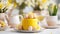 Elegant cake with yellow icing on cake stand, Easter eggs in white bowl, vase with yellow fresh tulips on white table
