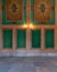 Elegant carved green frames on orange wall with ornate border and lanterns over marble floor