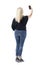 Elegant casual clothed middle age woman with blond hair in jeans taking selfies from above