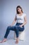 Elegant and Chic: Vertical Studio Portrait of a Young Woman in Blue Jeans and Bare Feet