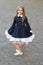 Elegant and classy. Happy child make curtsy in uniform outdoors. Dress code. Formal style. Fashion school uniform