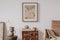 Elegant composition of masculine room decor with small wooden cupboard, two mockup paintings and vintage accessories.