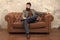 Elegant and confident. Man of fashion. Fashion model relaxing on sofa. Bearded man enjoying casual fashion style