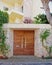 Elegant contemporary house entrance wooden door and red flowers