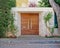 Elegant contemporary house entrance wooden door and red flowers